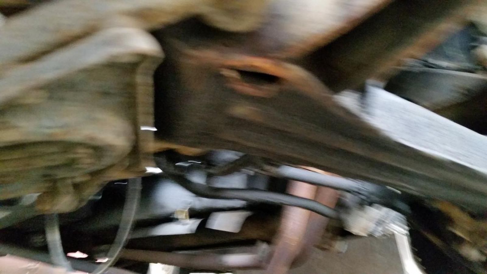 A close up of a motorcycle engine with a hose coming out of it.