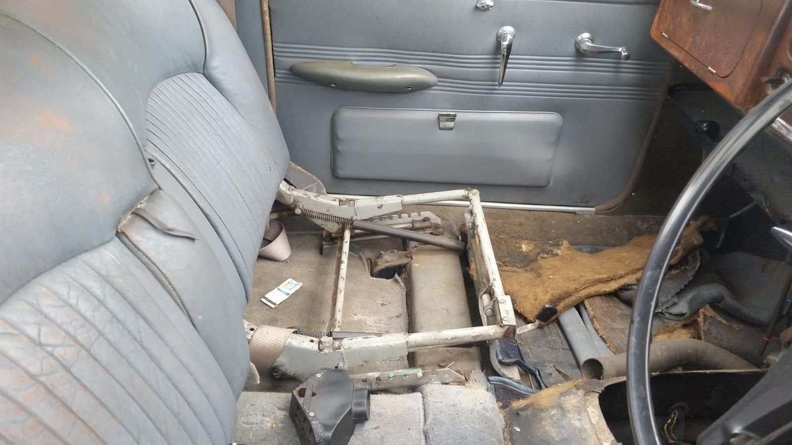A car with a broken seat and a steering wheel.