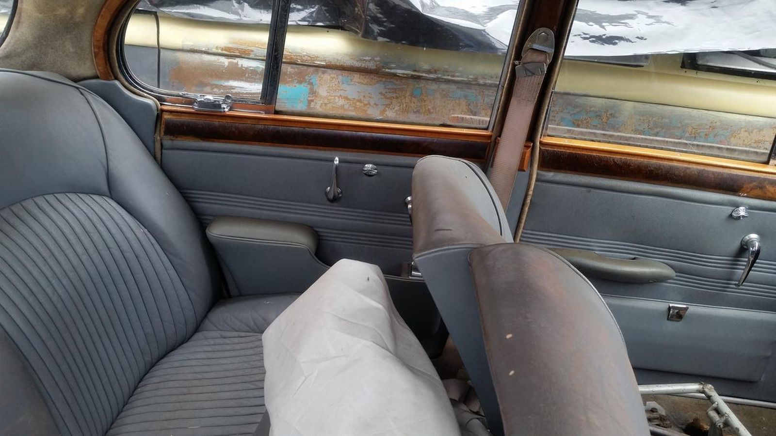 The inside of a car with a broken seat and a broken window.