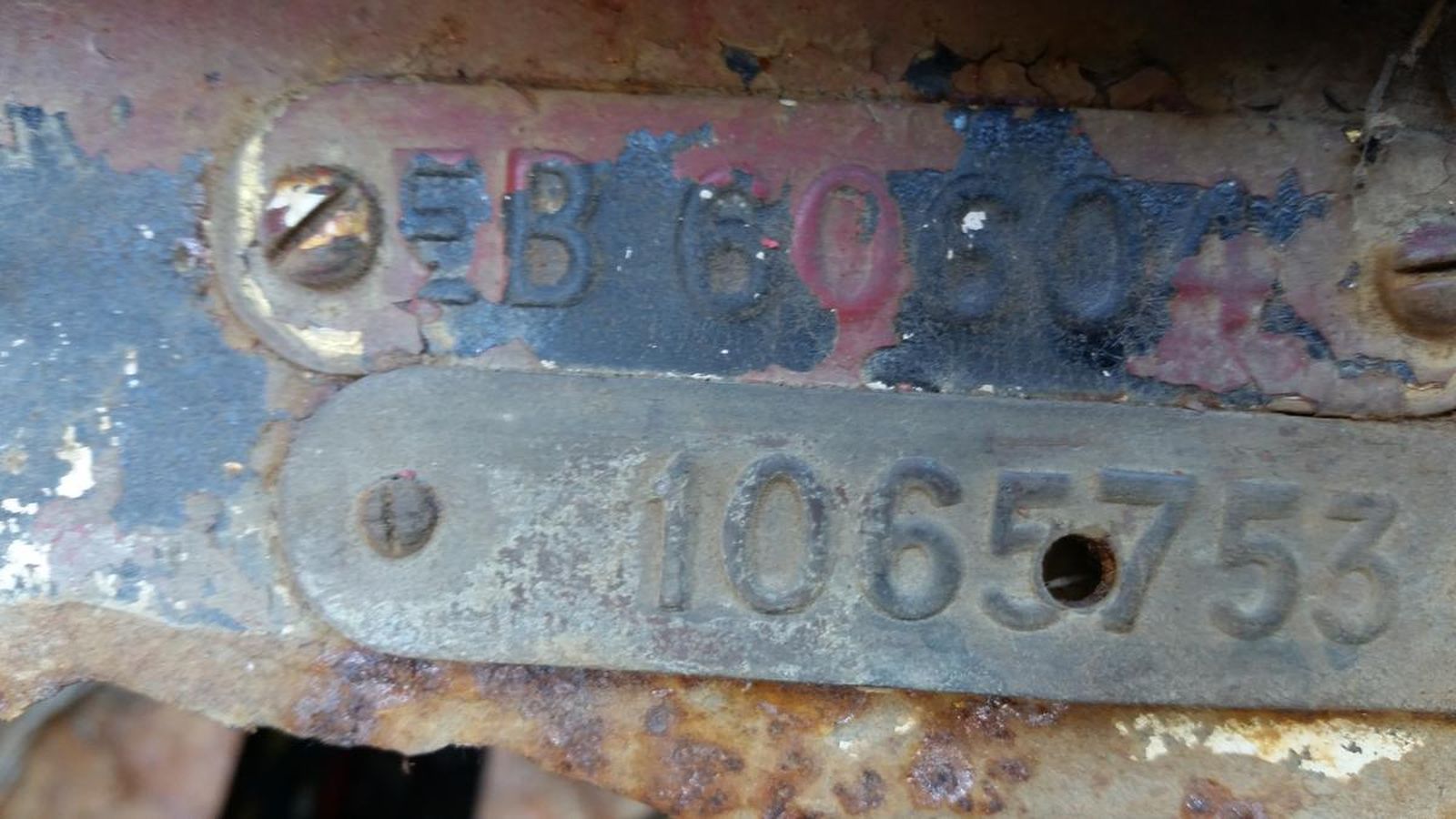 A close up of a rusty piece of metal with a number on it.
