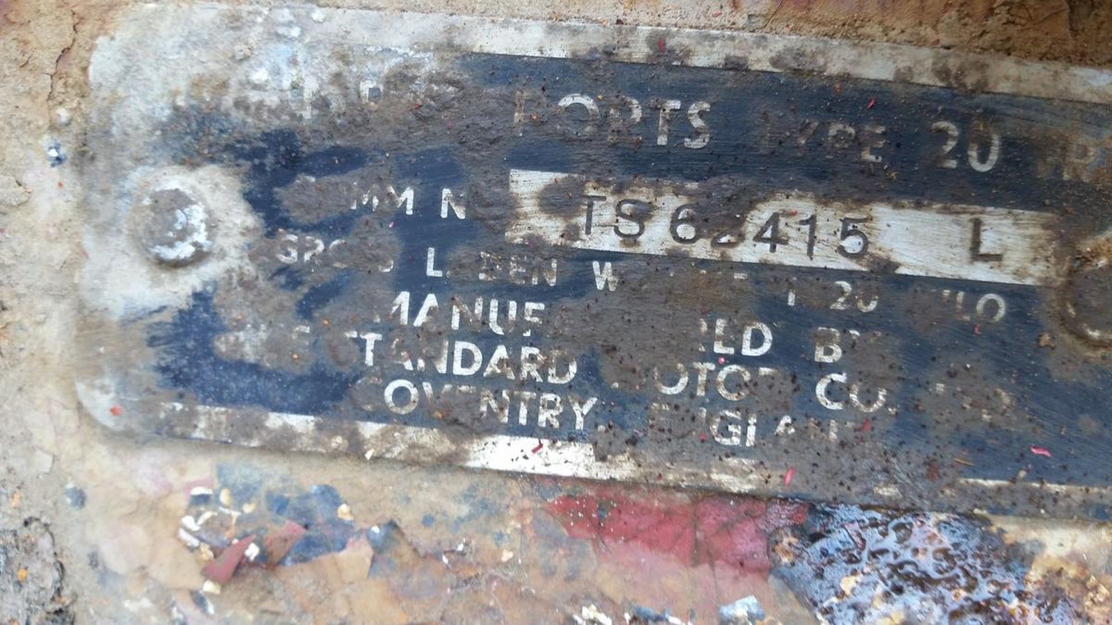 A close up of a rusty metal plate with numbers on it