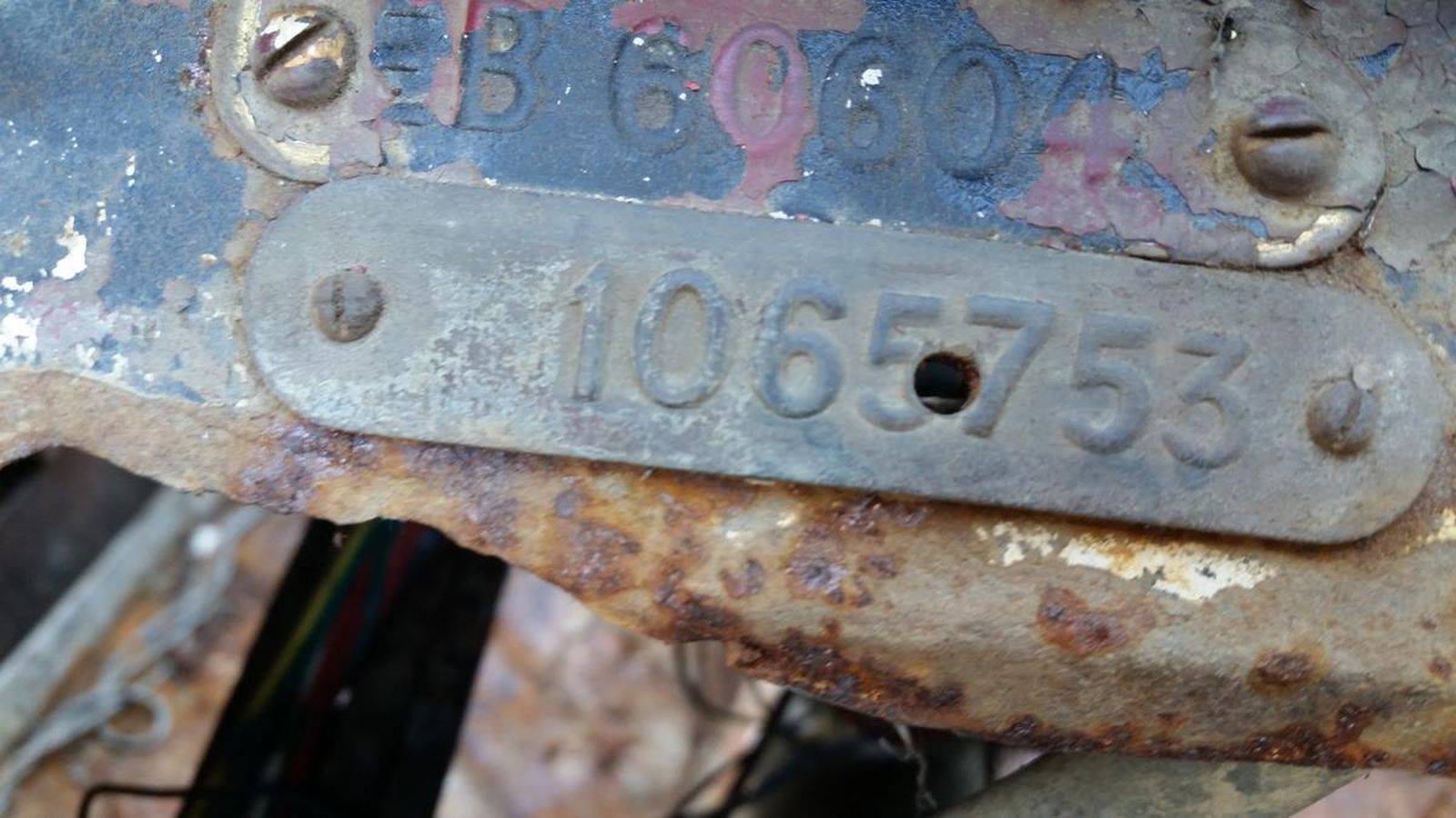 A close up of a rusty metal plate with a number on it.
