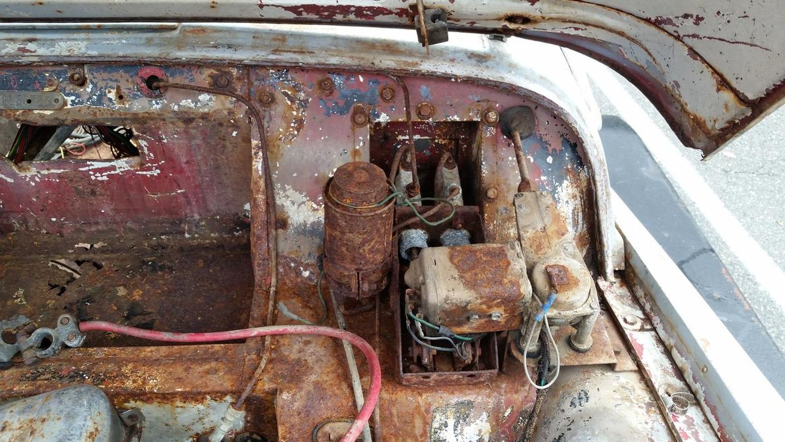 The hood of an old rusty car with the hood open