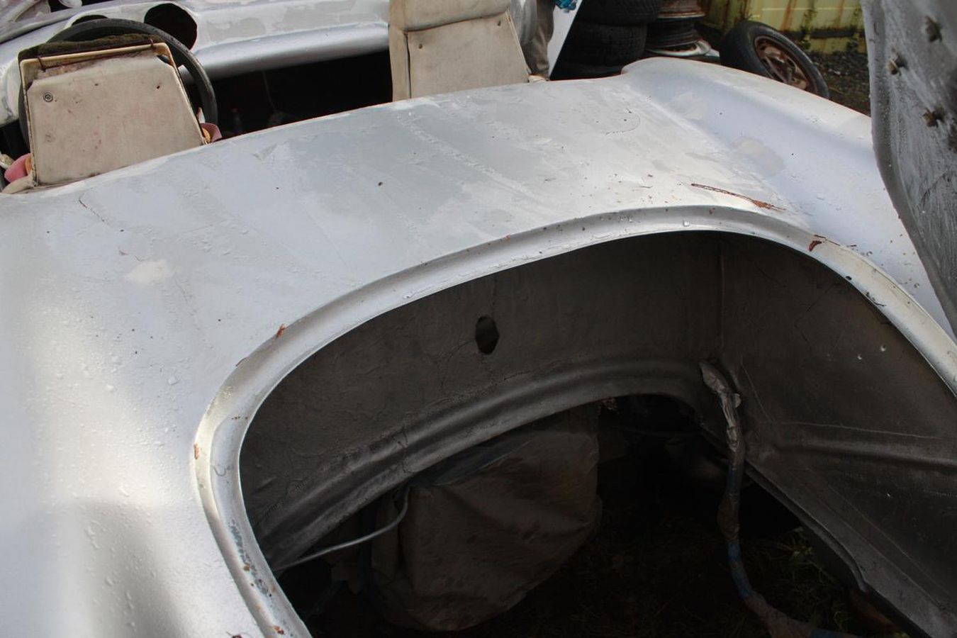 The trunk of a silver car with the hood open