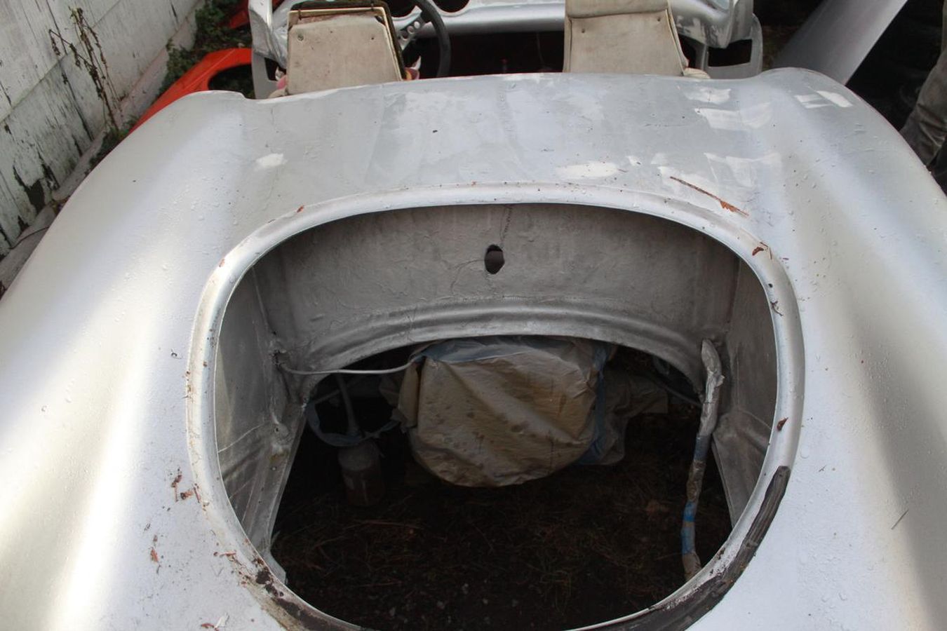 A silver car with a hole in the middle of it