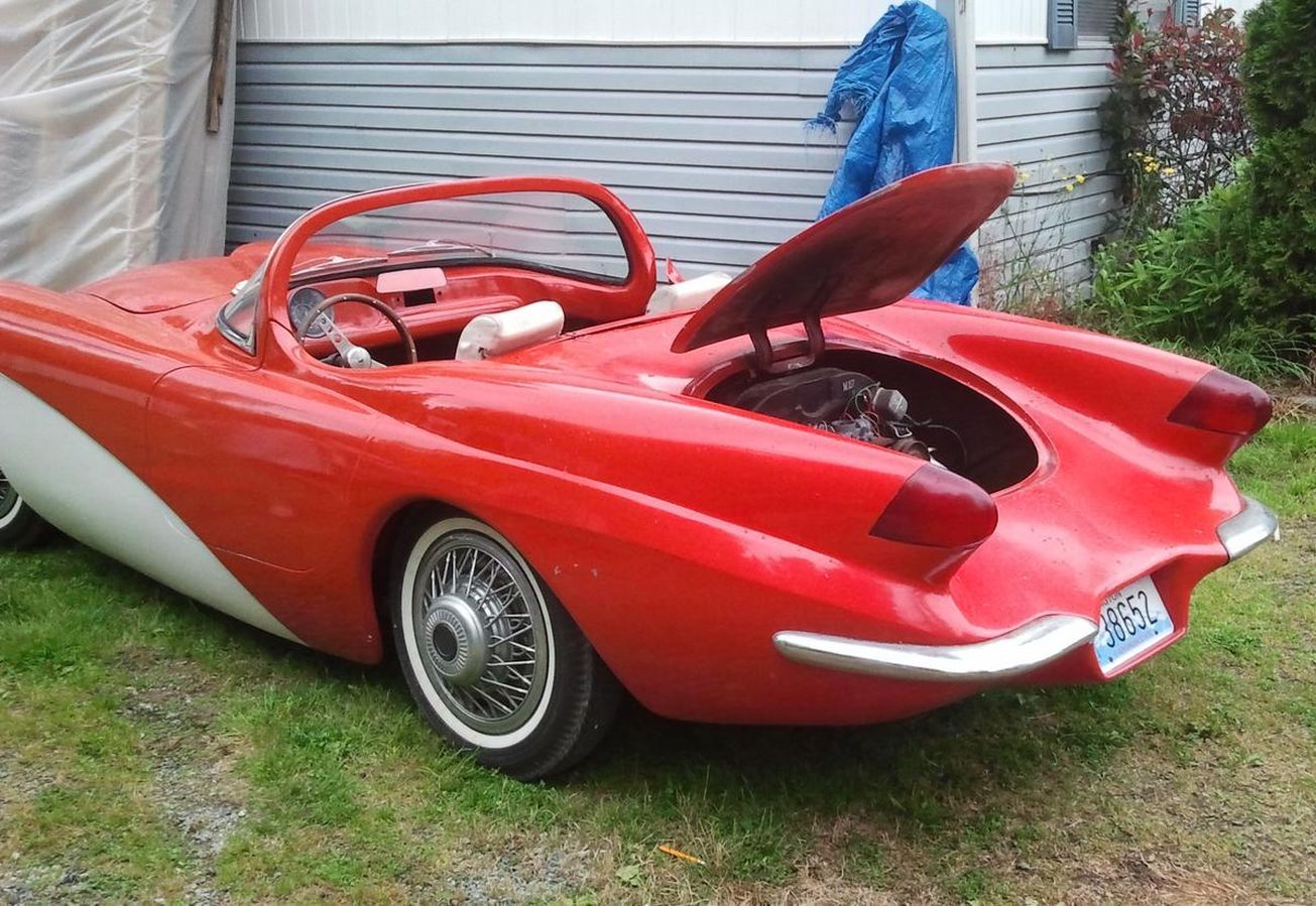A red and white sports car with the hood up
