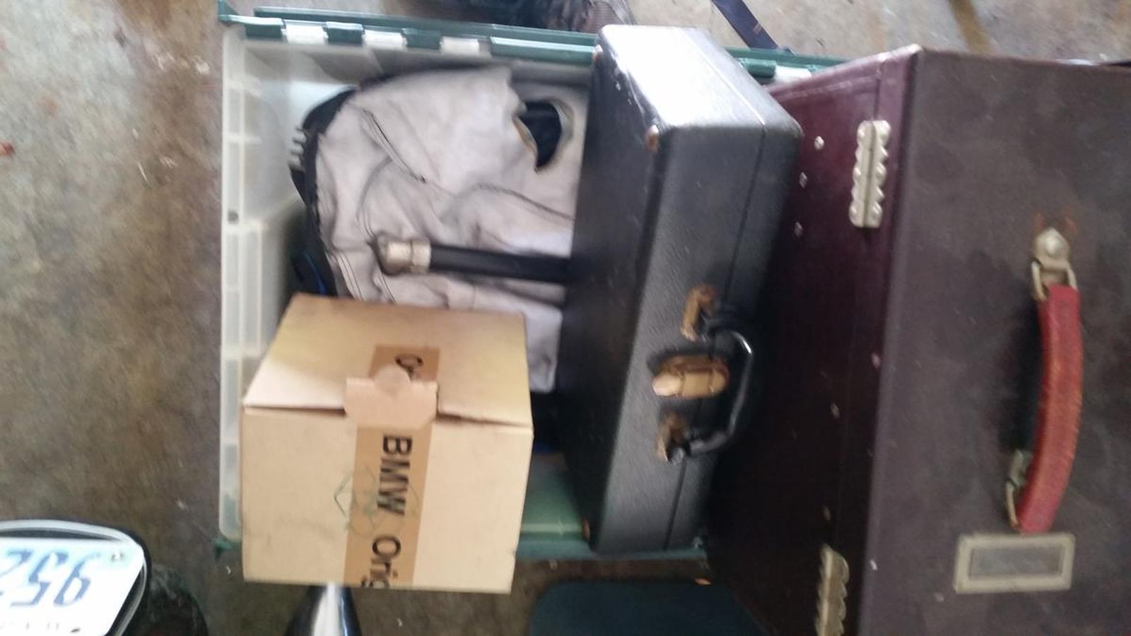 A bmw box is taped to a suitcase