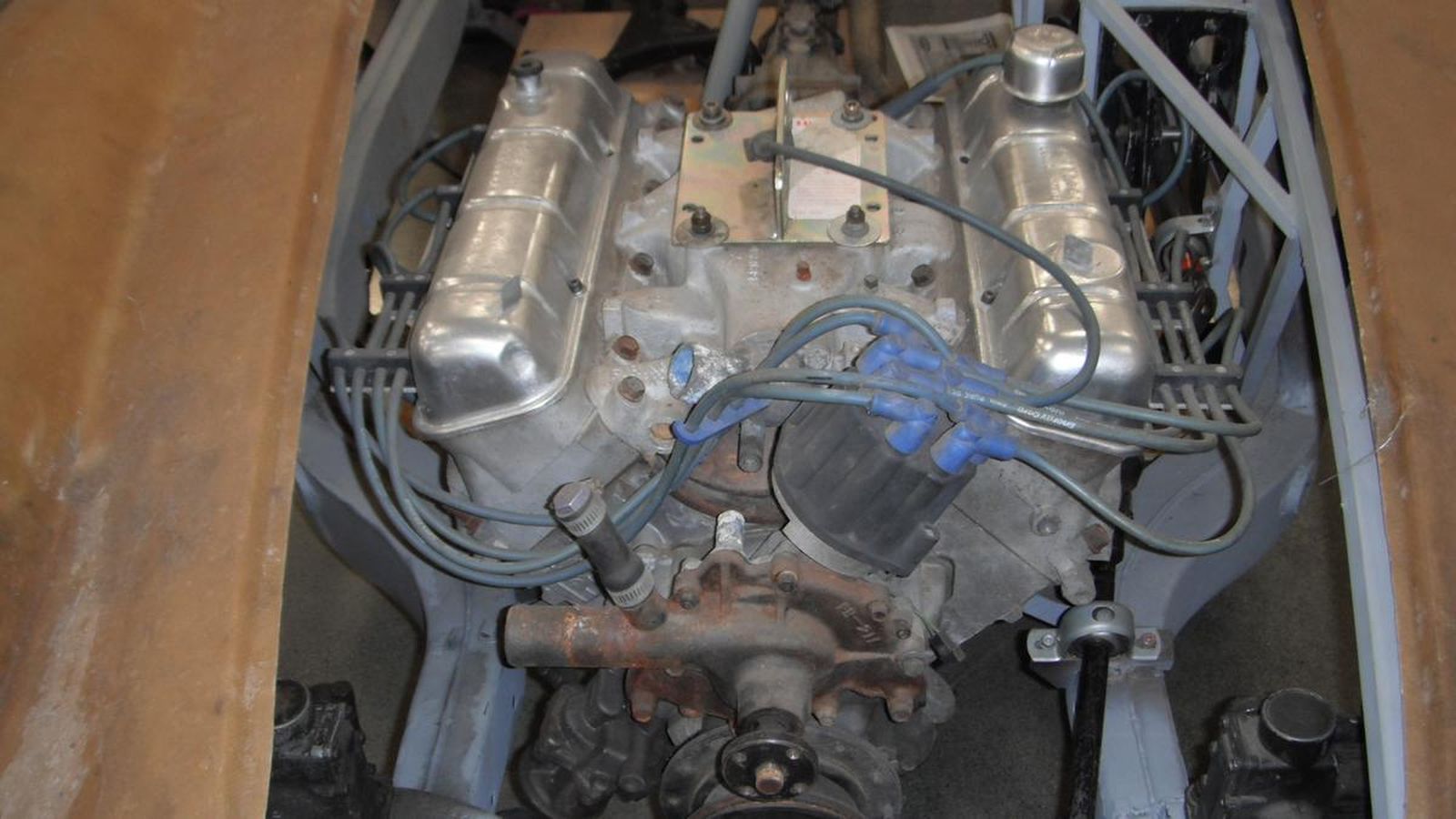 A close up of a car engine with wires coming out of it