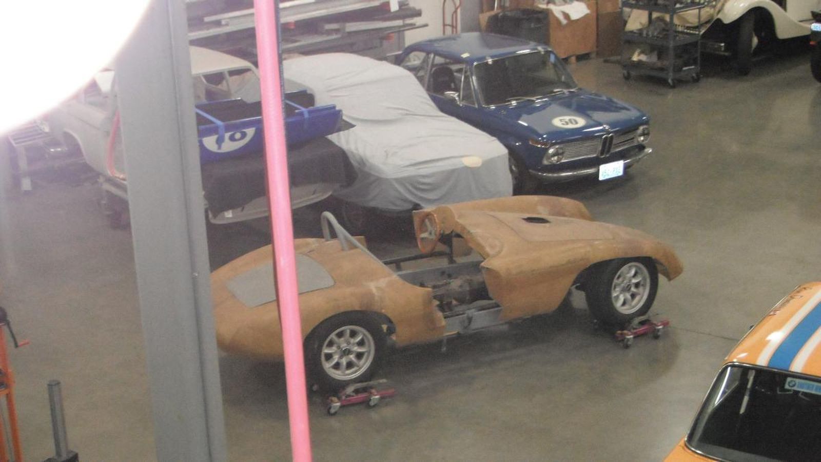 A group of cars are sitting in a garage.