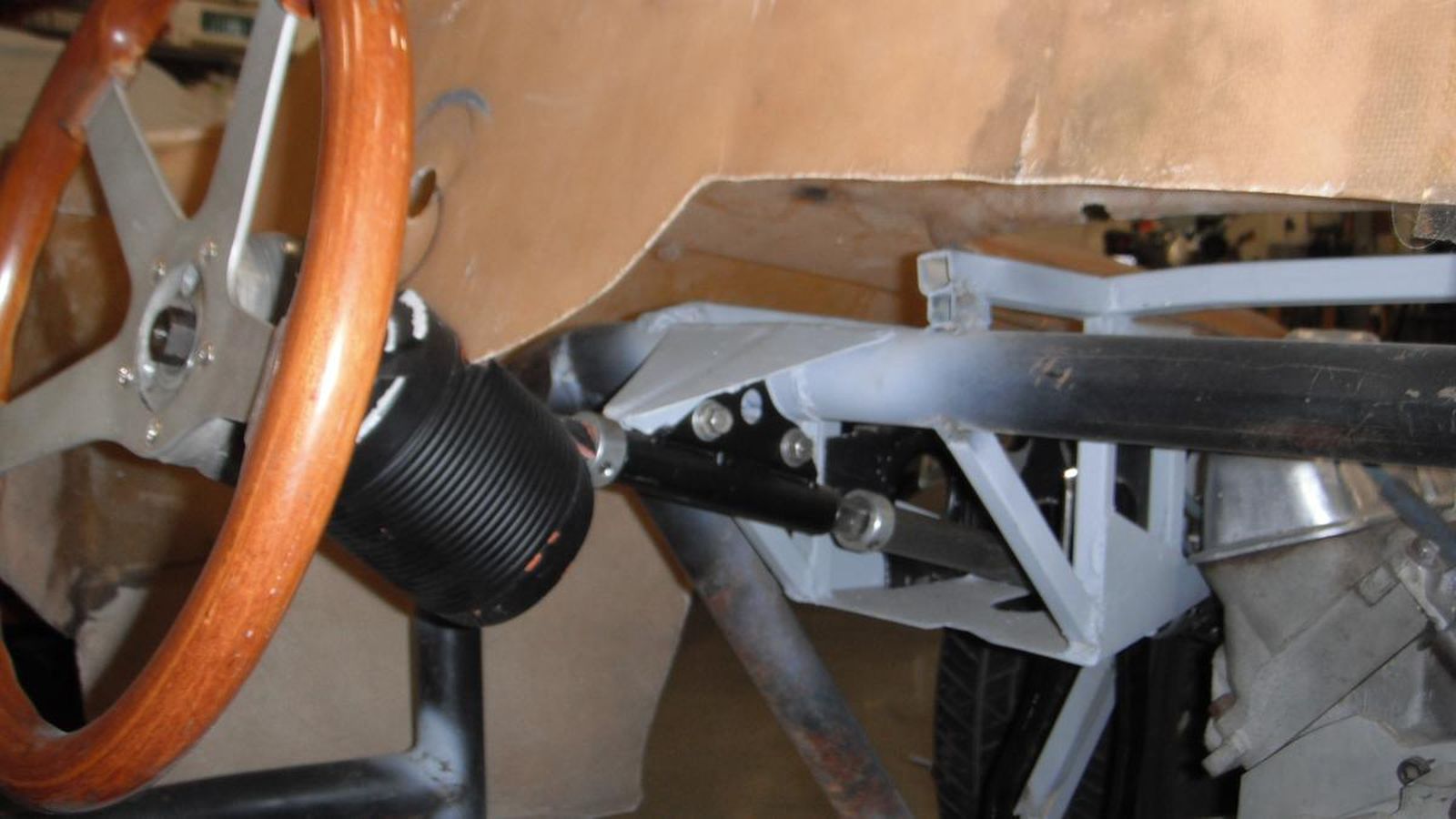 A wooden steering wheel is sitting on top of a black chair