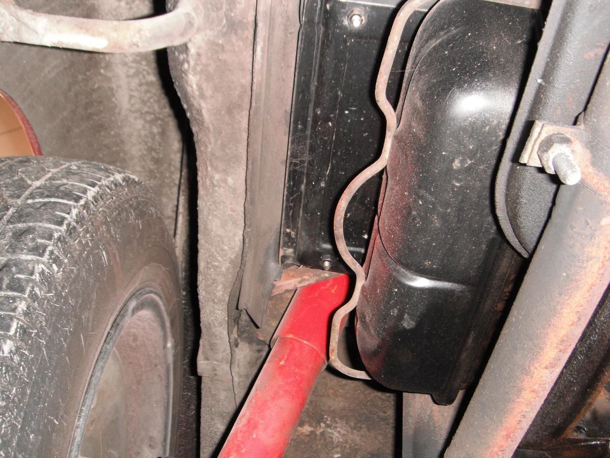A red pipe is attached to the side of a car