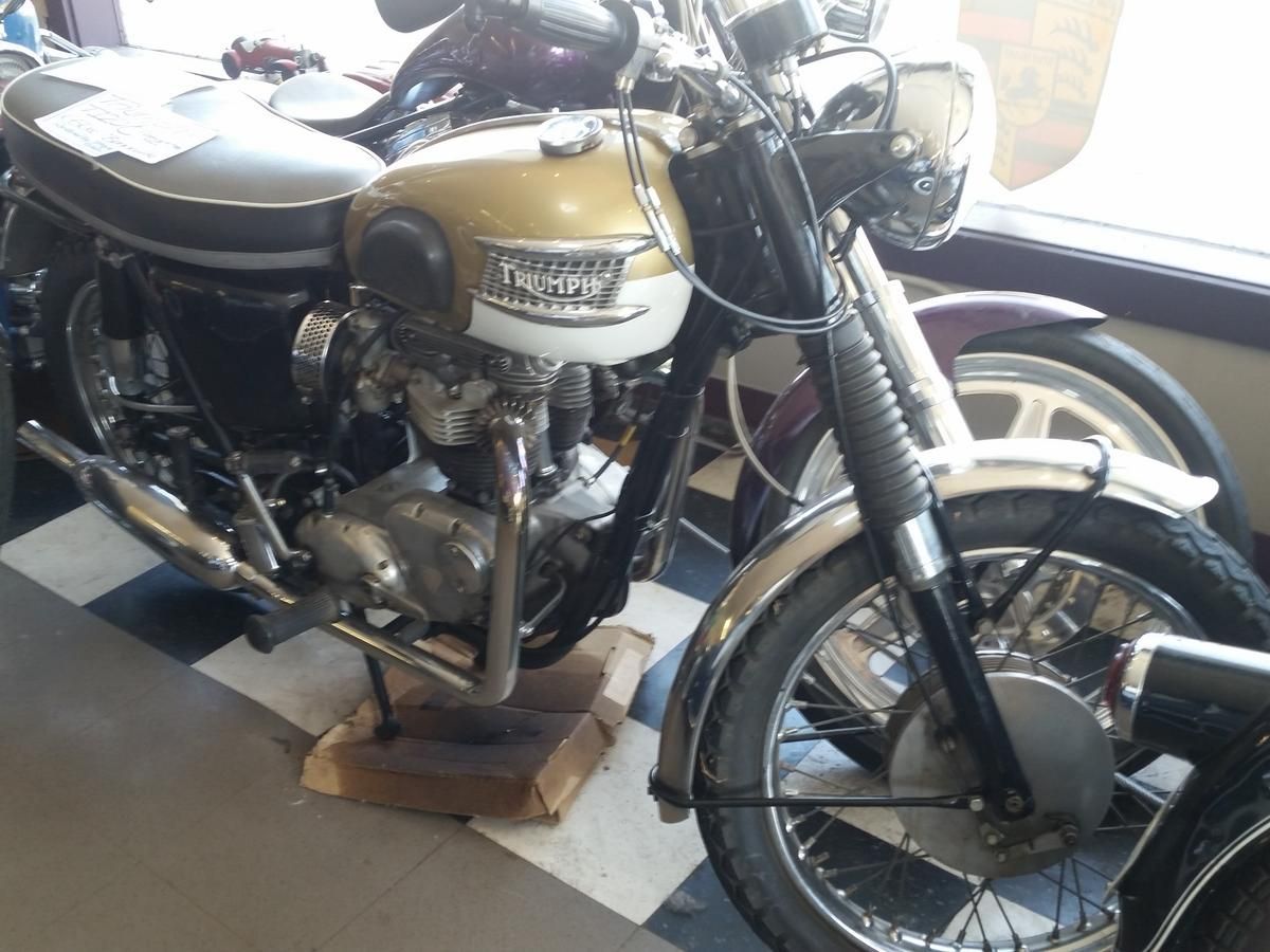 A triumph motorcycle is parked on a checkered floor