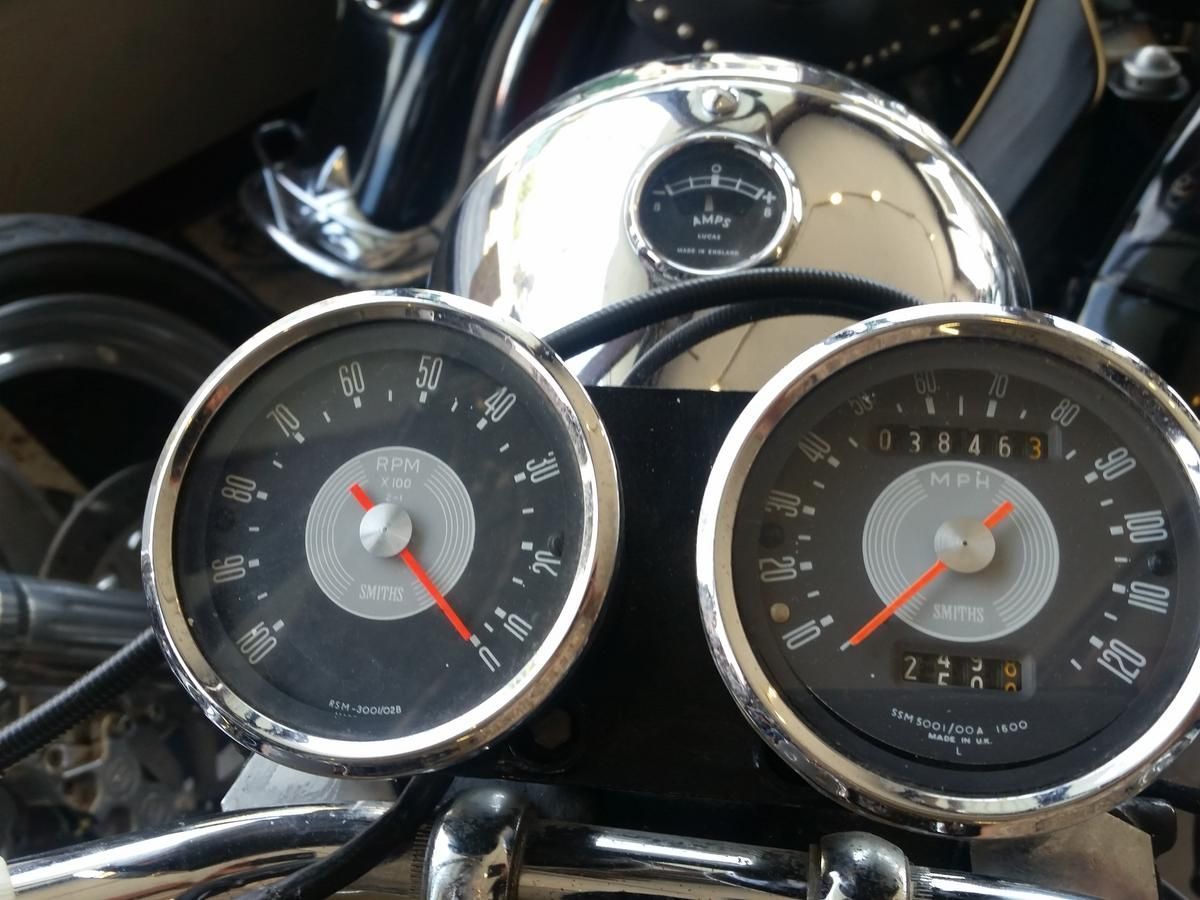 A close up of a motorcycle dashboard with a tachometer and a fuel gauge