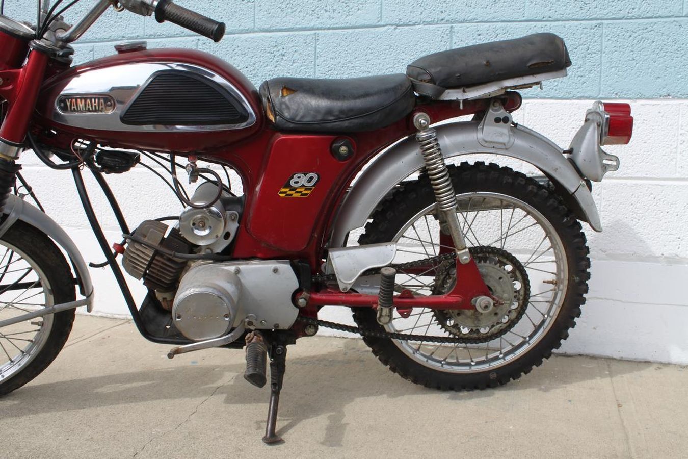 A red yamaha motorcycle is parked on the sidewalk