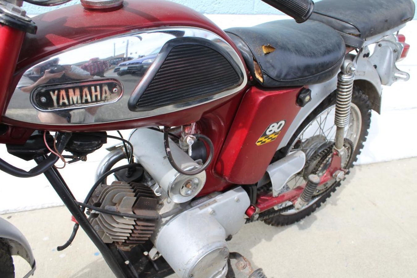 A red yamaha motorcycle is parked on the sidewalk
