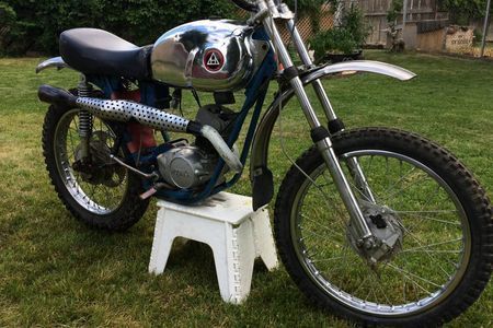 a motorcycle is parked on a white stool in the grass .