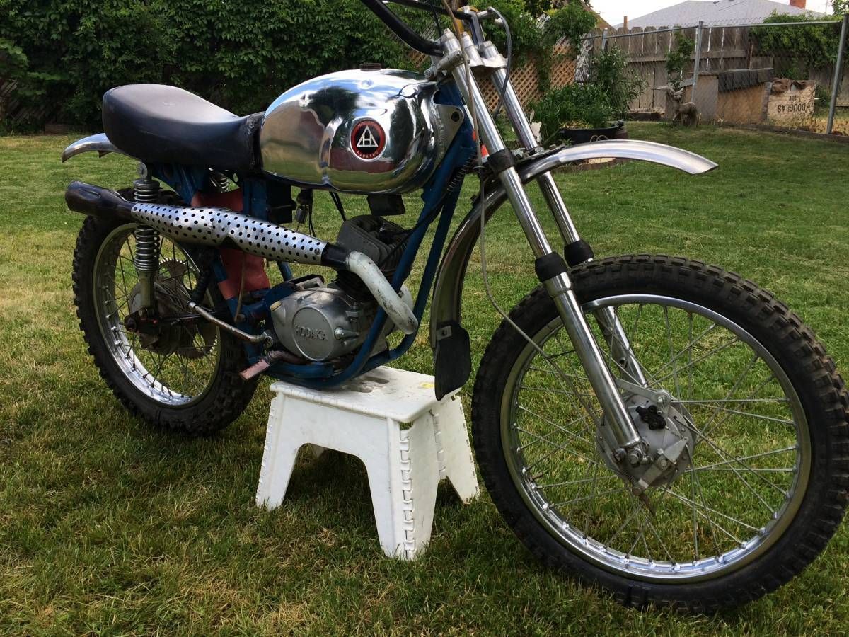 A motorcycle is parked on a white stool in the grass.