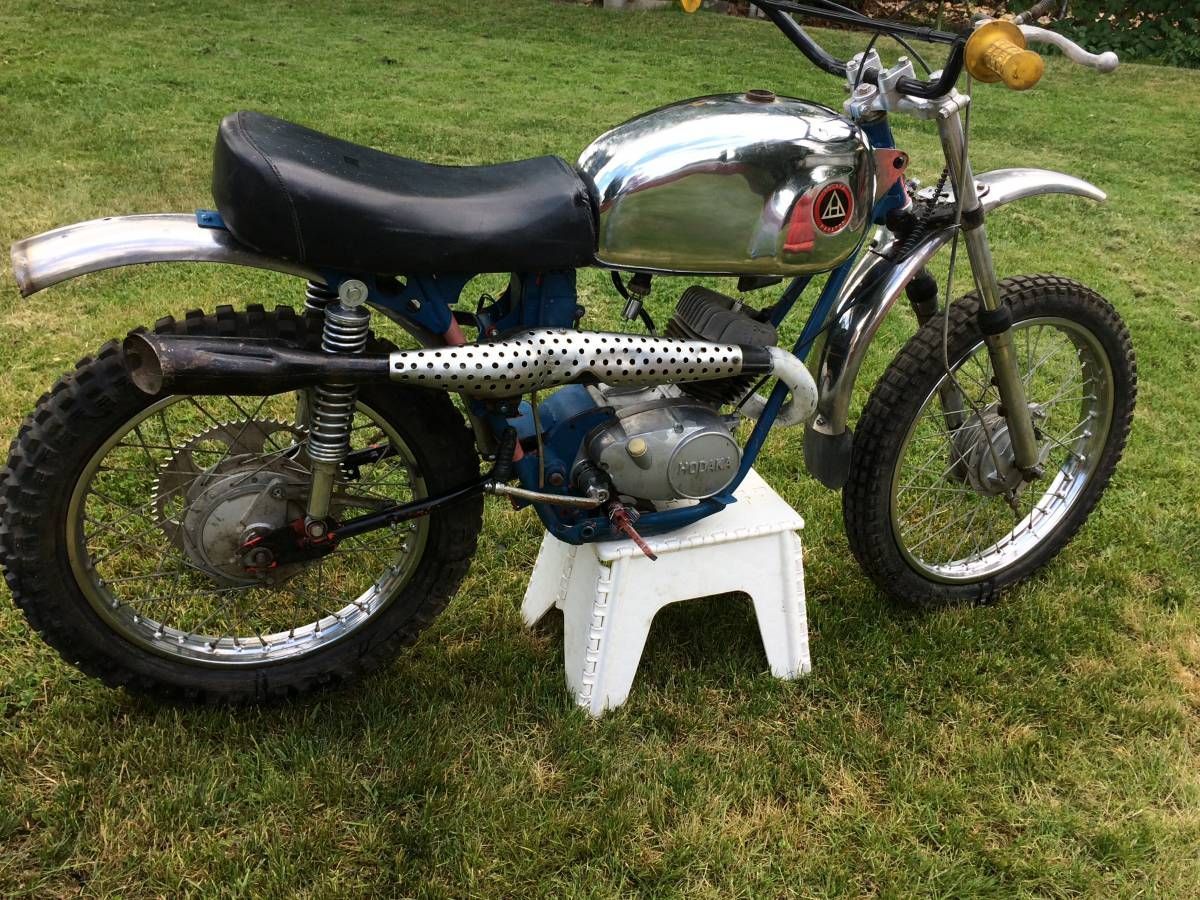 A motorcycle is parked on a white stool in the grass.
