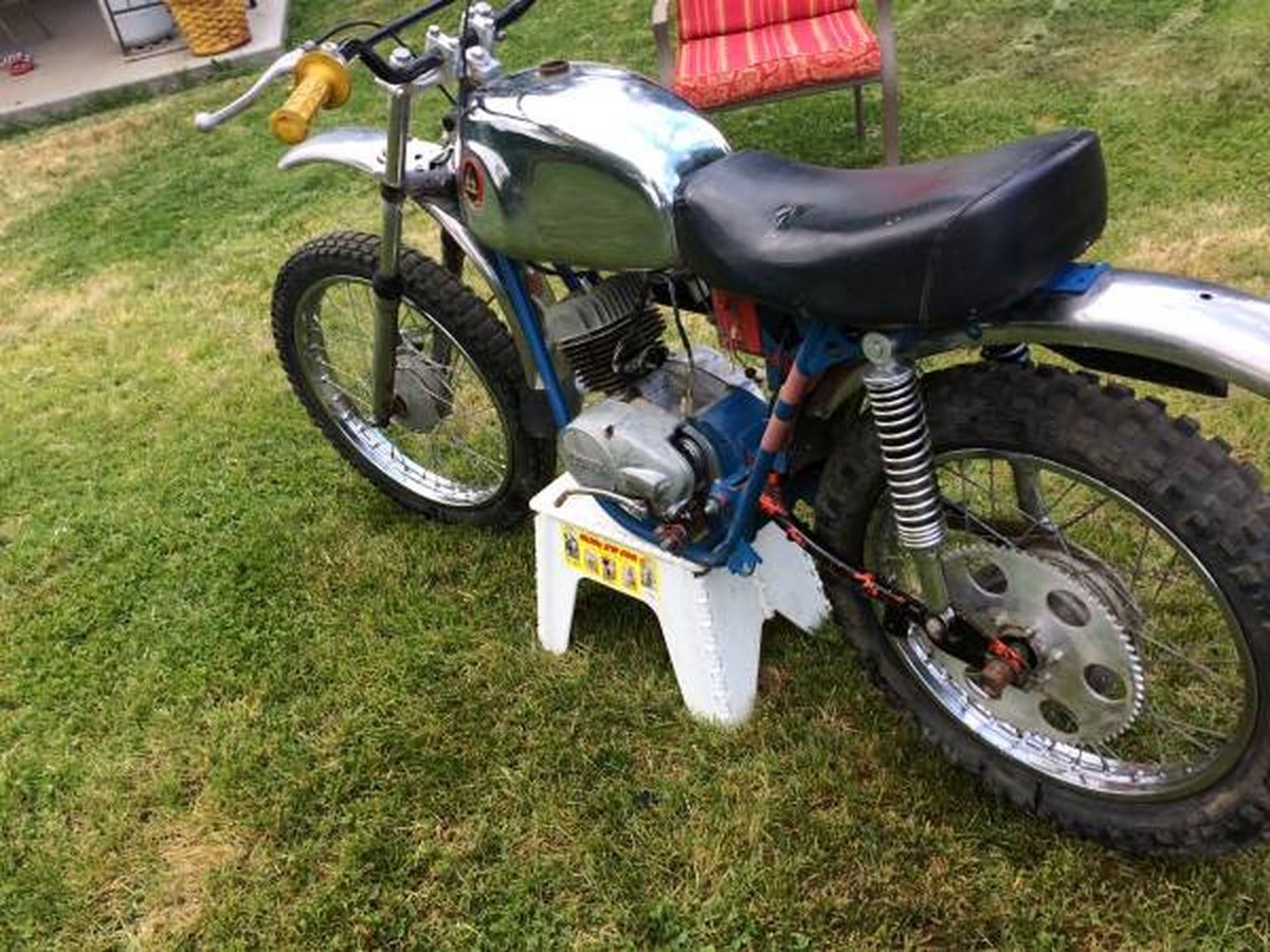 A motorcycle is parked on a white stool in the grass.