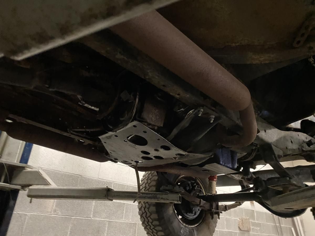 The underside of a car is shown in a garage