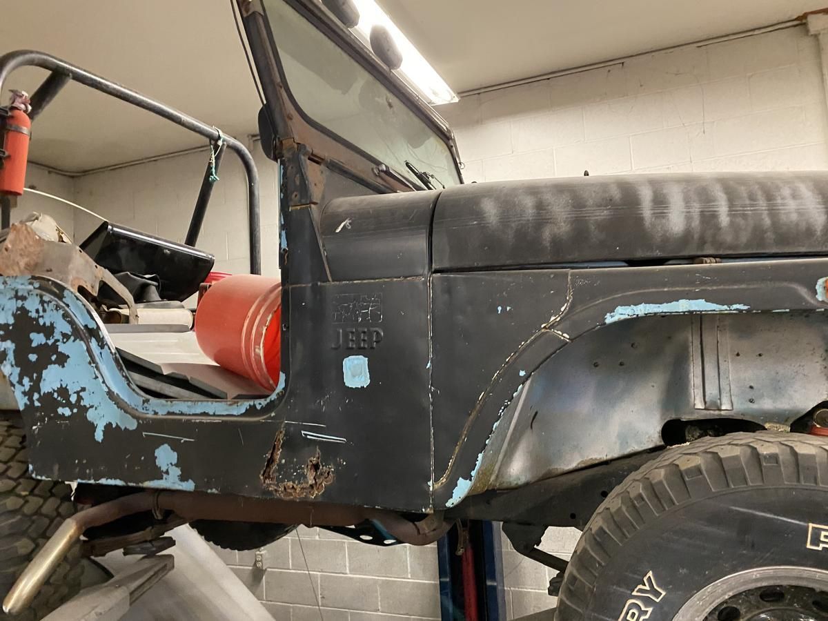 A jeep is sitting on a lift in a garage