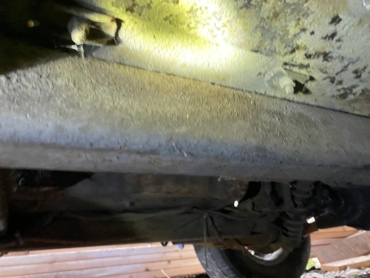 A close up of the underside of a car in a garage.