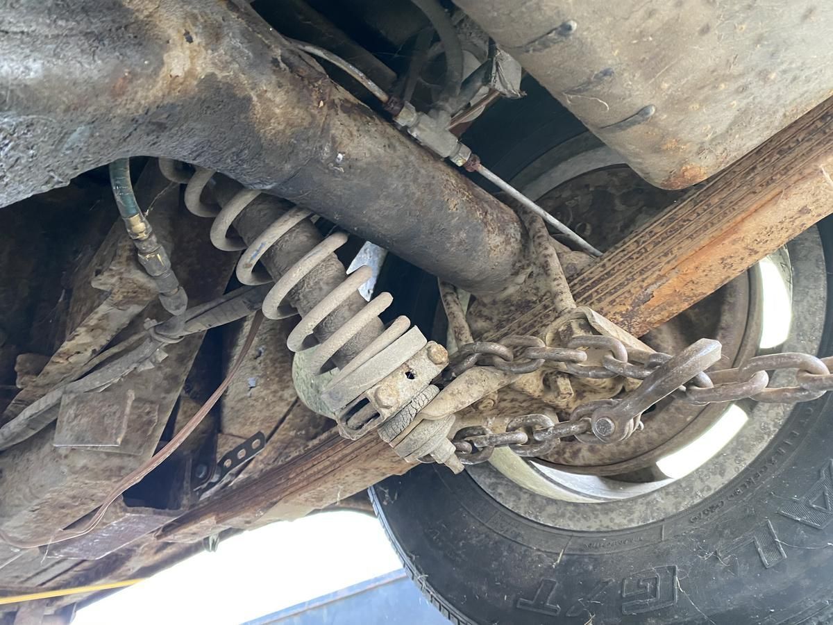 A close up of the underside of a car with a chain attached to it.