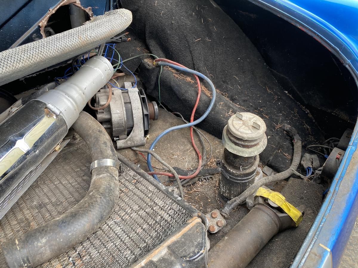 The inside of a blue car with a lot of wires coming out of it.
