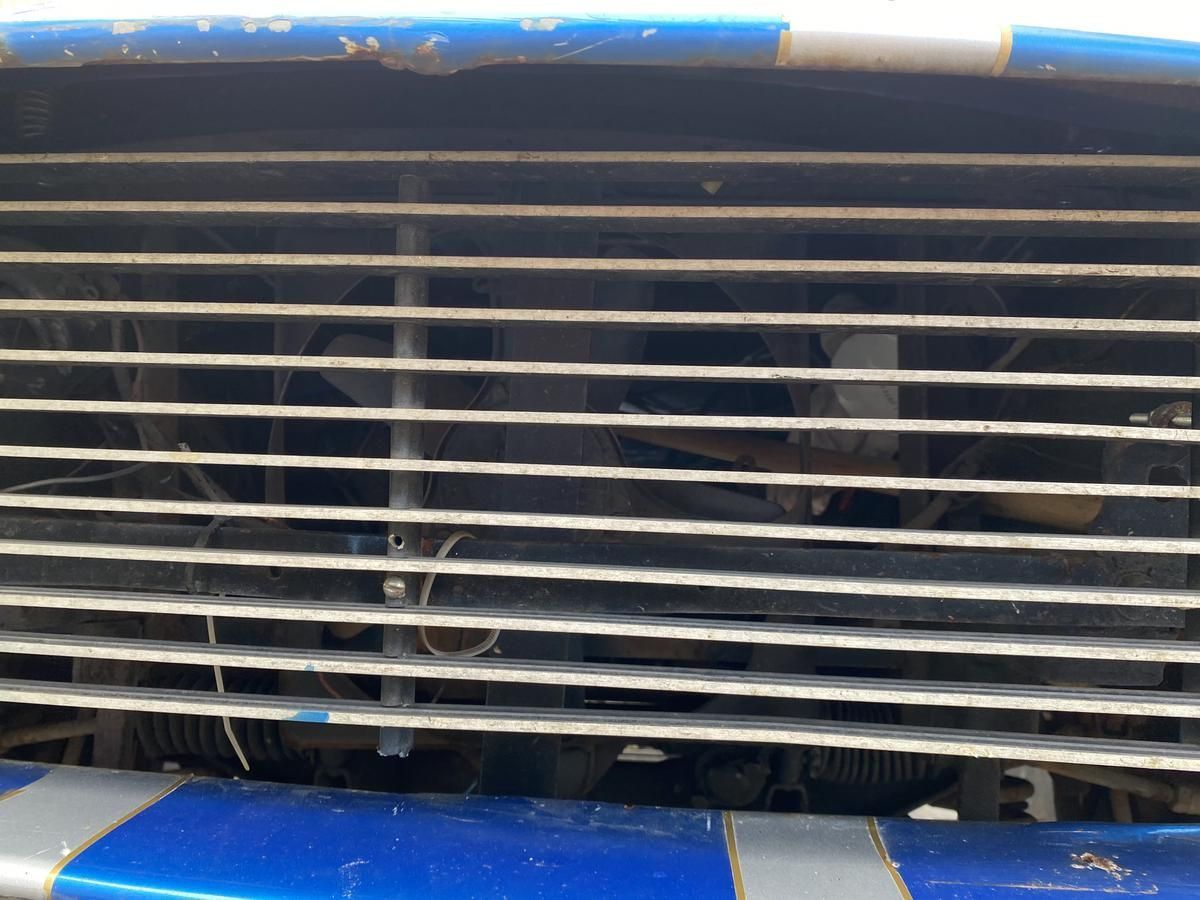 A close up of a grille on a blue and white car