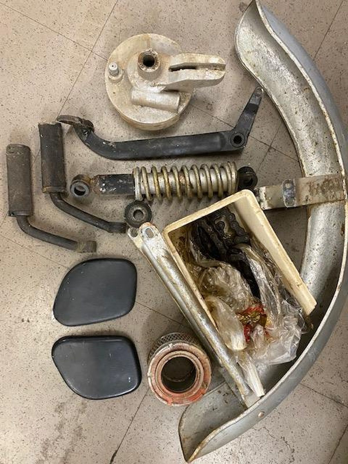 A bunch of motorcycle parts are sitting on the floor.