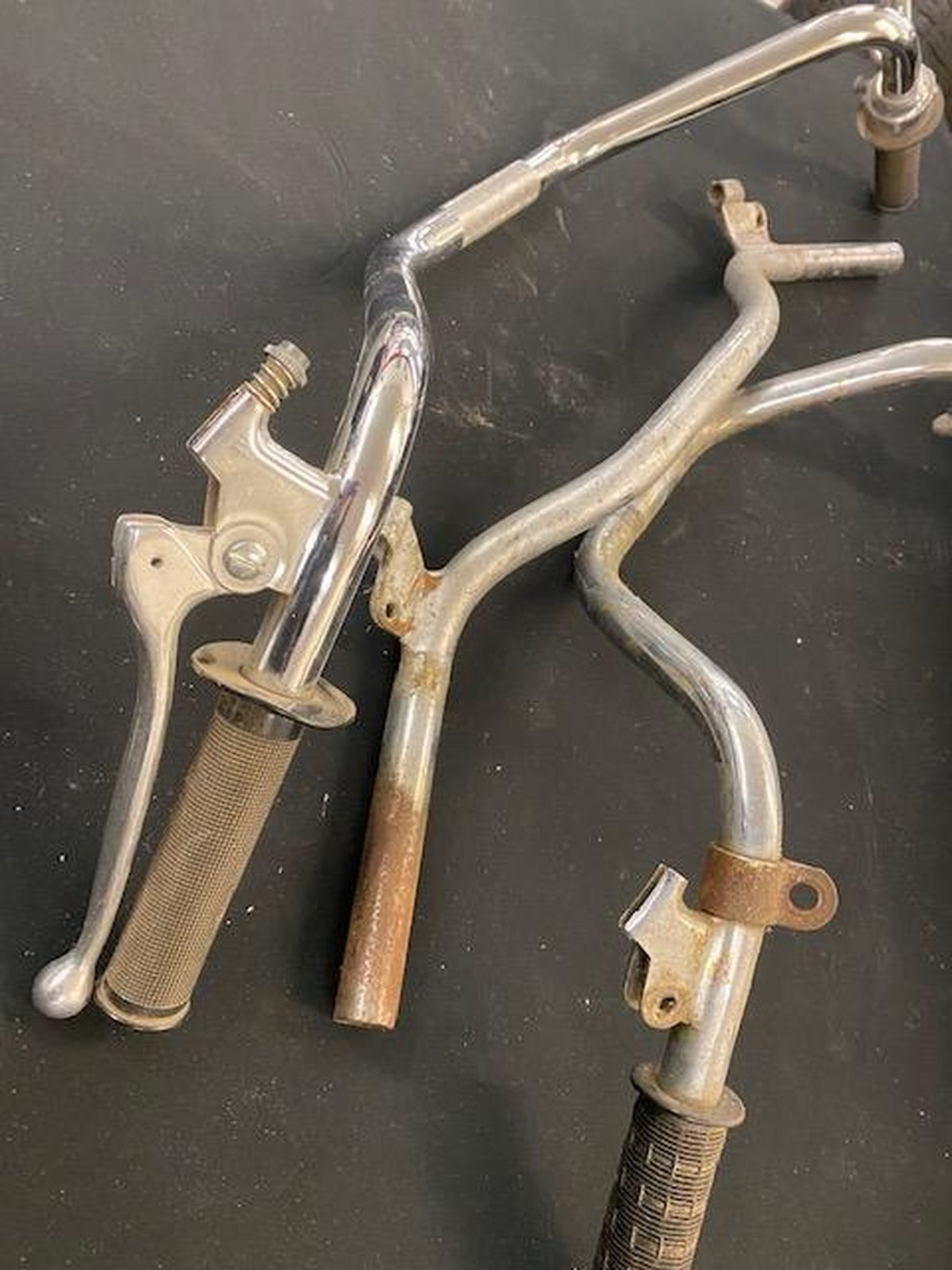 A close up of a bicycle handlebar on a black surface.