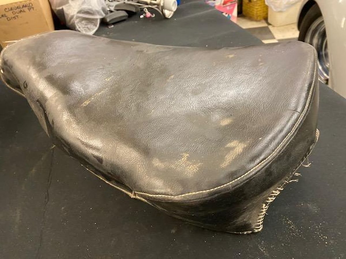 A black leather seat is sitting on top of a black table.