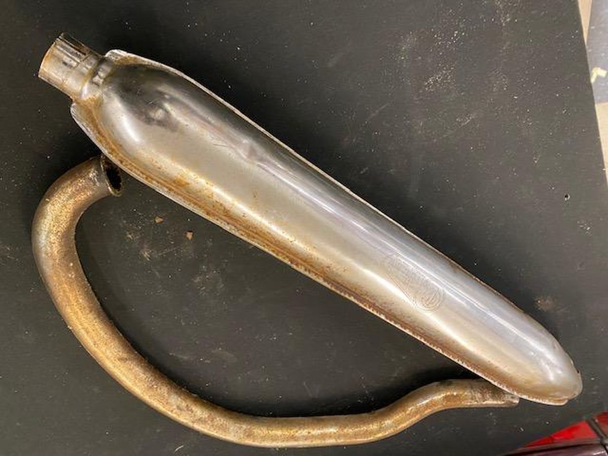 A metal pipe is sitting on a black surface.