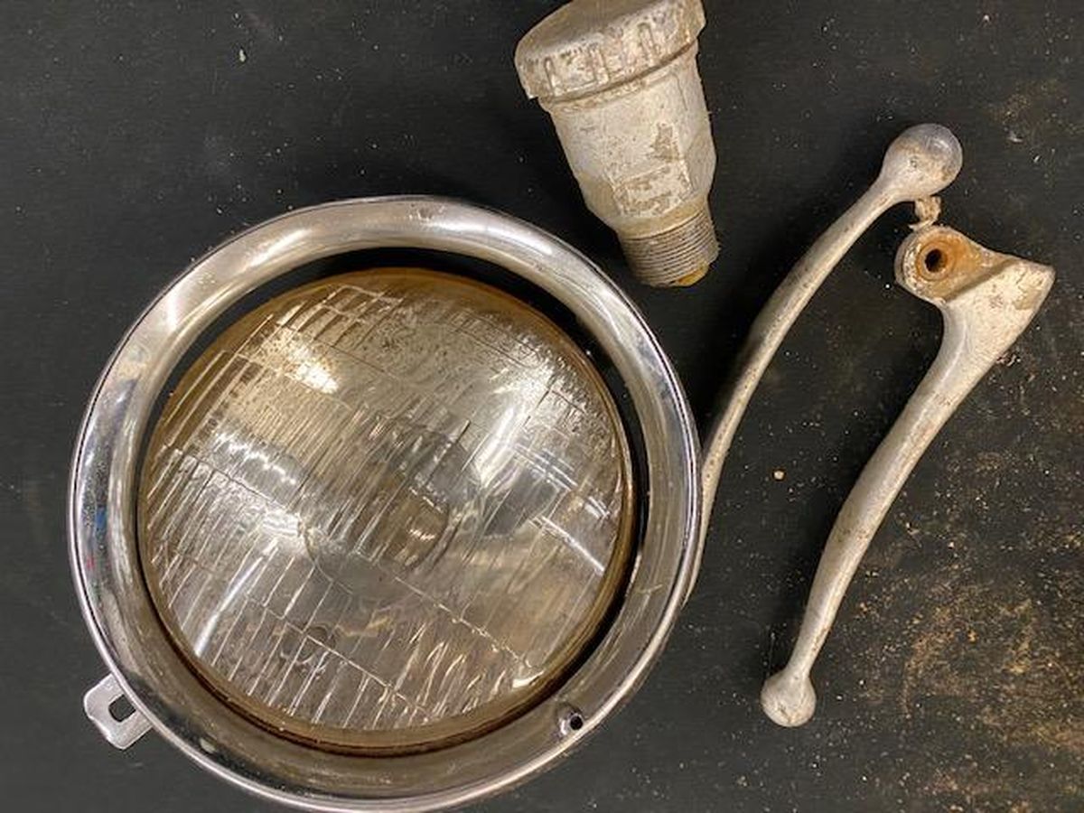 A close up of a headlight and a brake lever