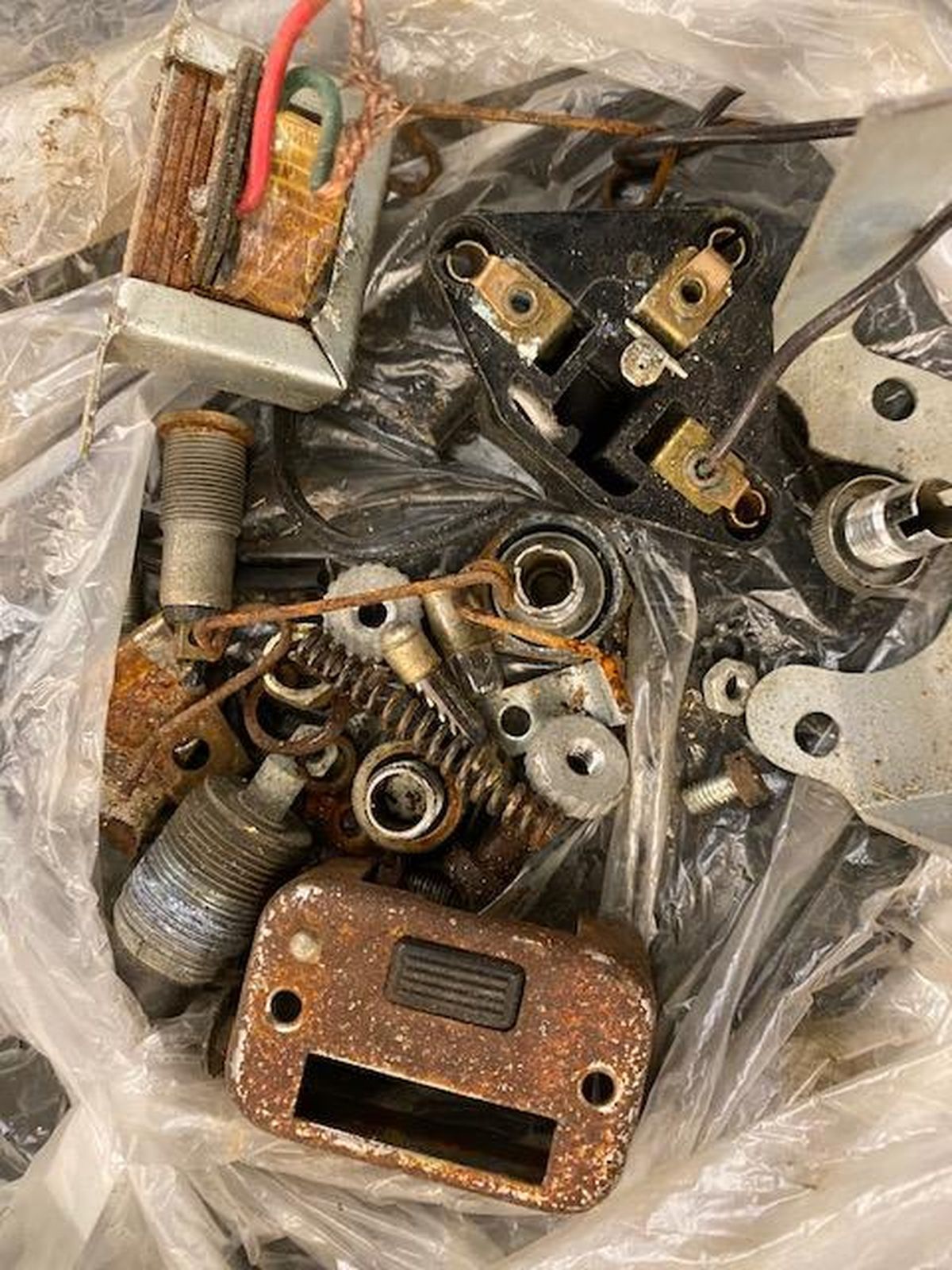 A pile of rusty metal parts in a plastic bag.