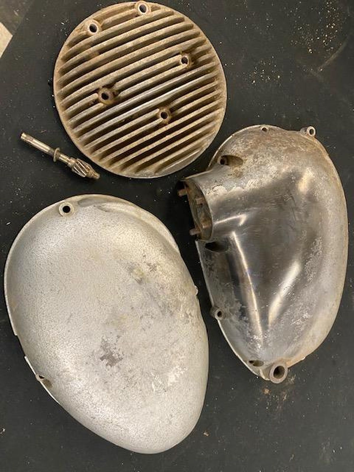 Three pieces of metal are sitting on a black surface.