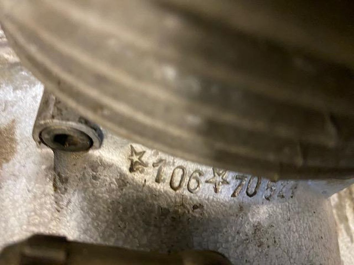A close up of a motorcycle engine with a number on it.