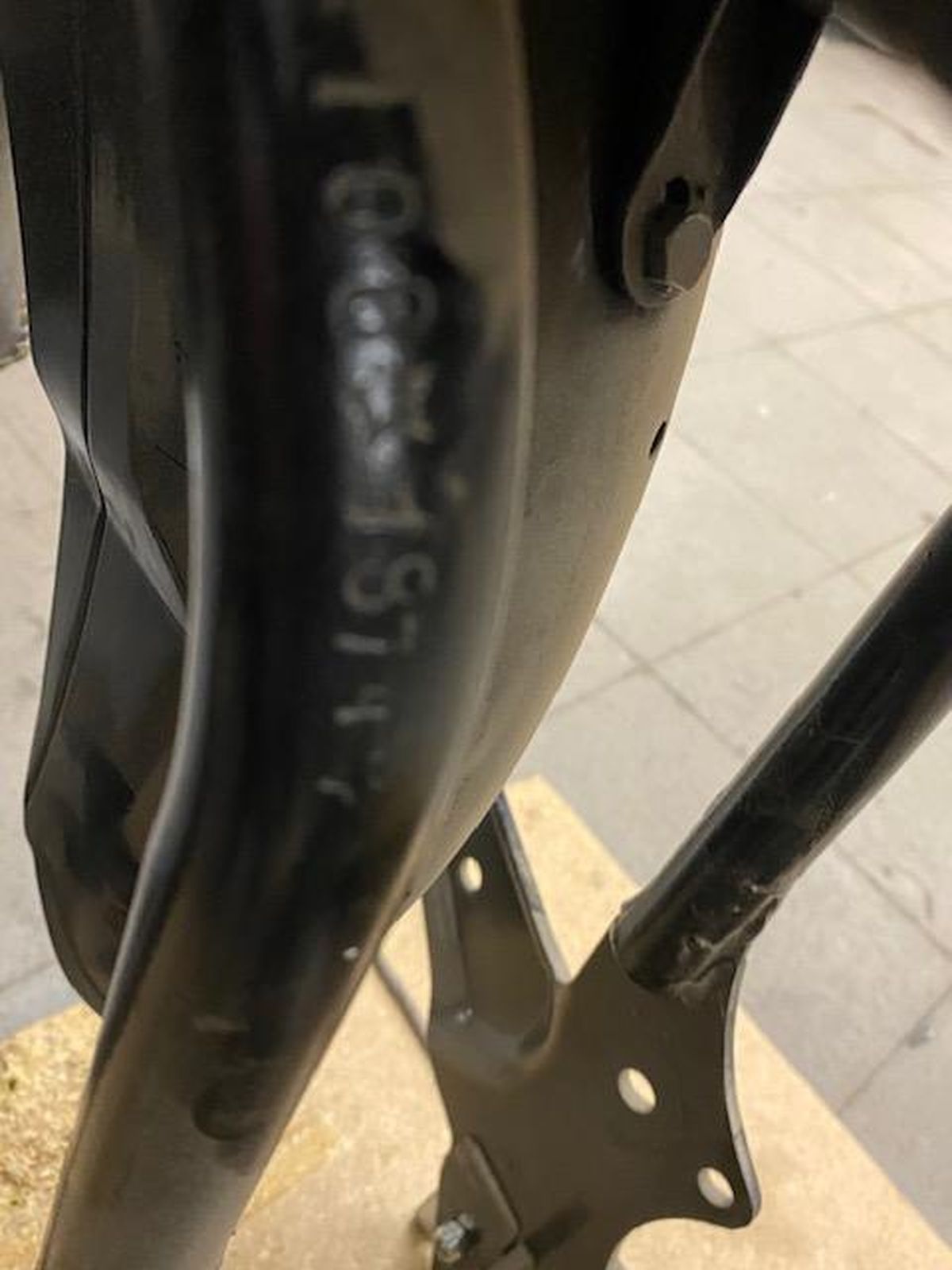 A close up of a motorcycle frame with a serial number on it
