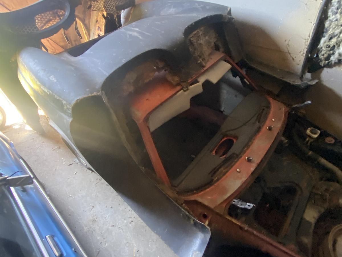 A car is sitting in a garage with the hood open