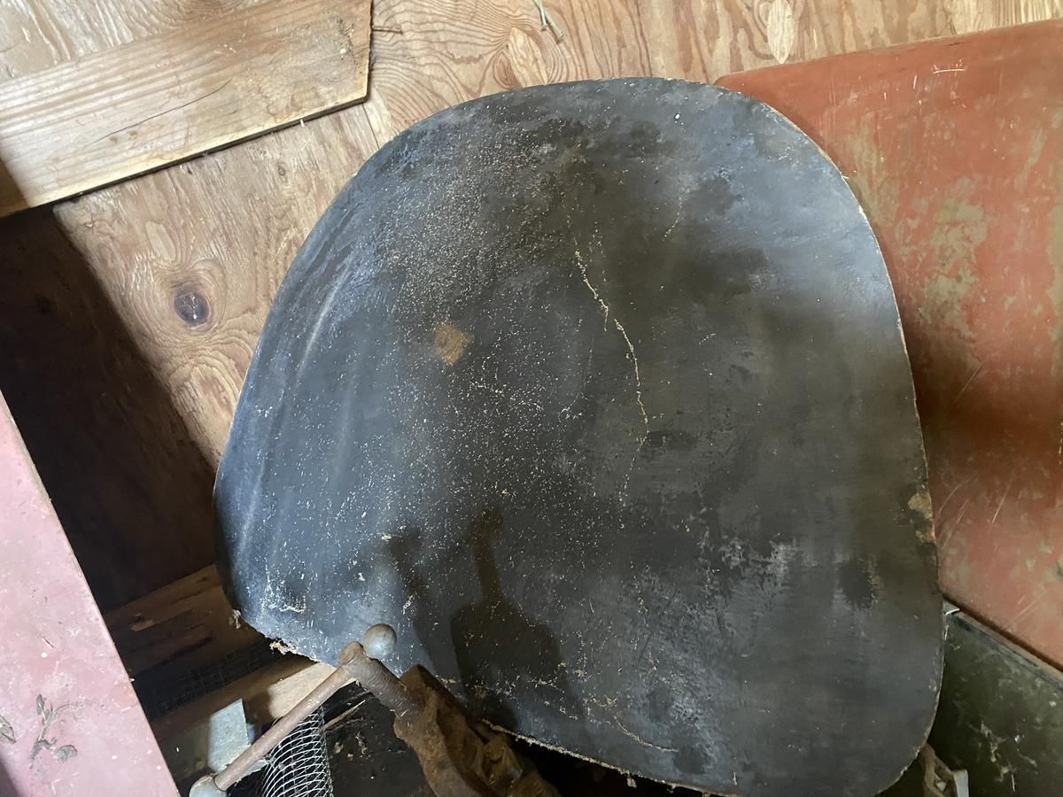 A piece of metal is sitting on top of a wooden table.