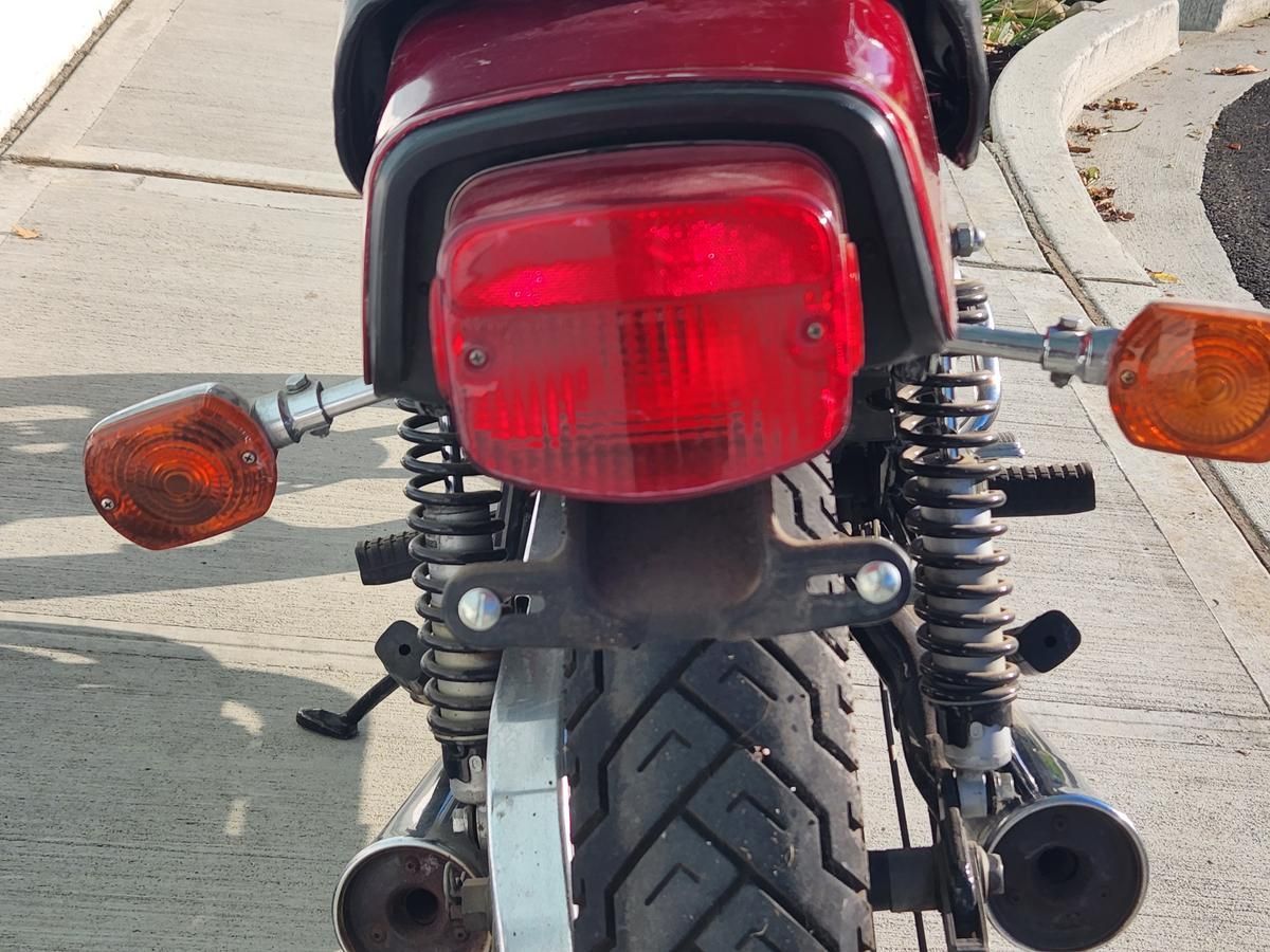 A red motorcycle is parked on the side of the road