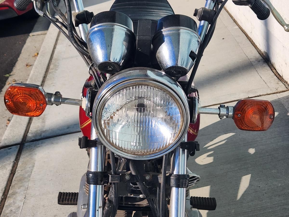 A motorcycle is parked on a sidewalk next to a building