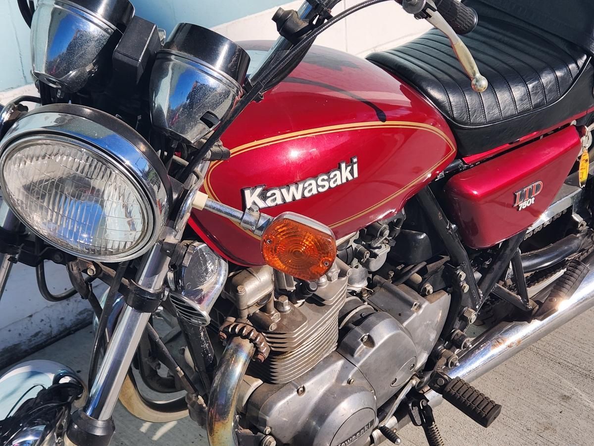 A red kawasaki motorcycle is parked on the side of the road