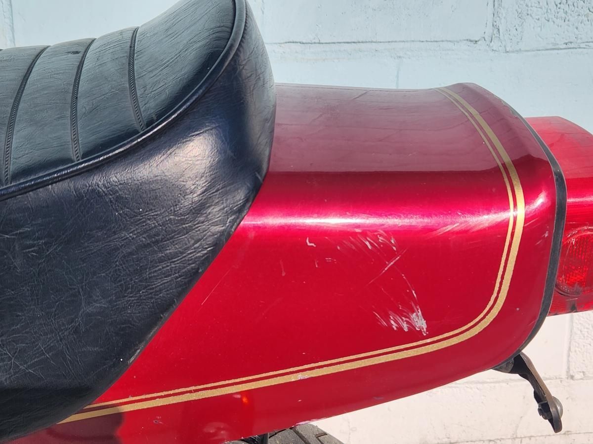 The back of a red motorcycle with a black seat