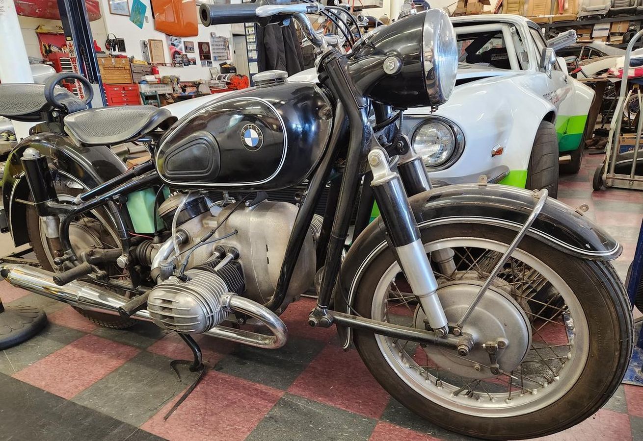 A black and silver motorcycle is parked in a garage.