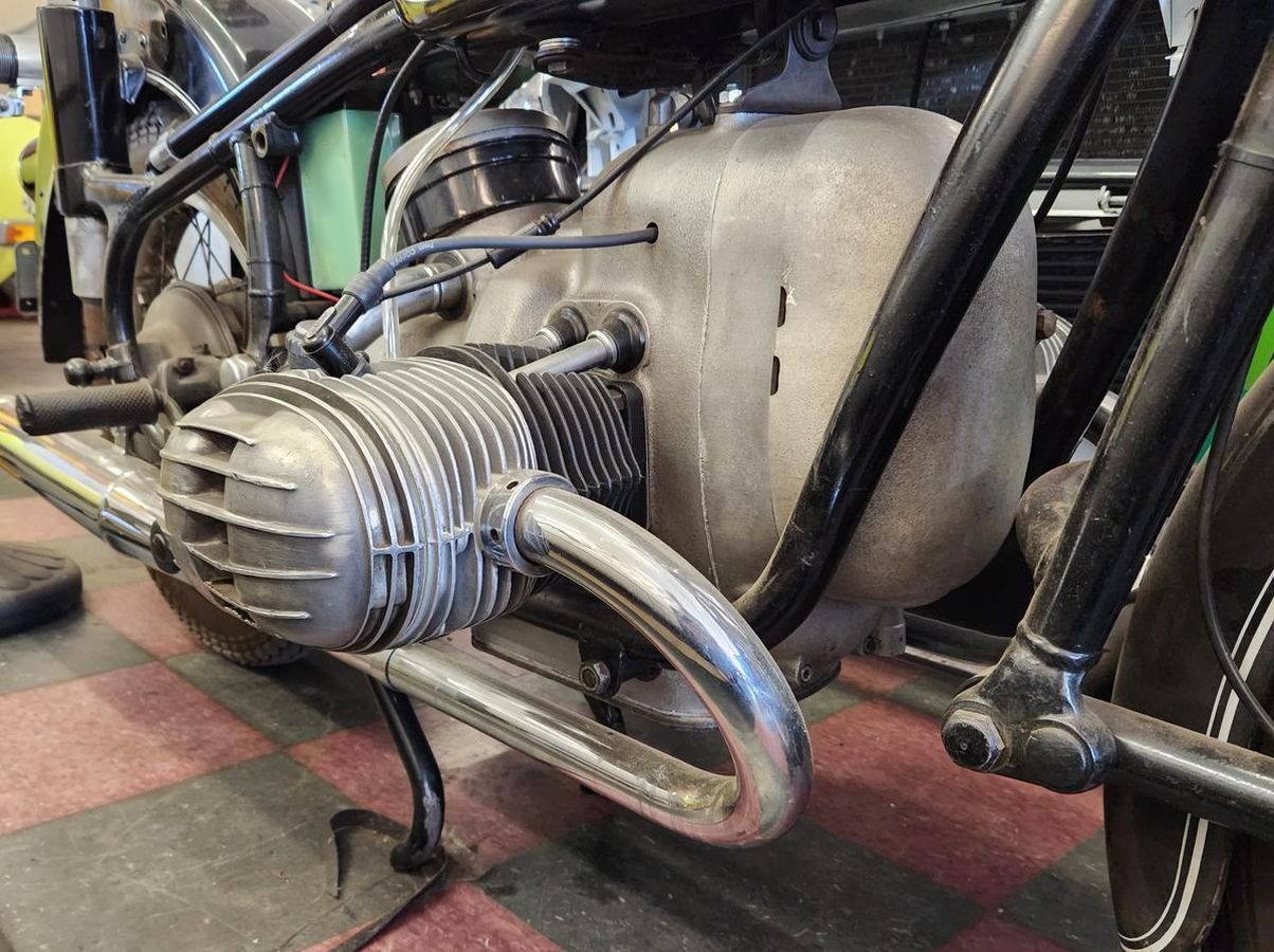 A close up of a motorcycle engine on a checkered floor.