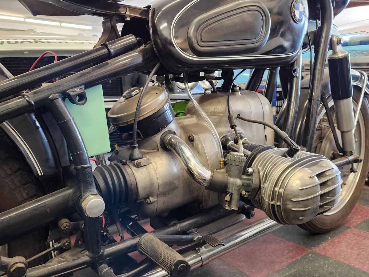 A close up of a motorcycle engine in a garage.