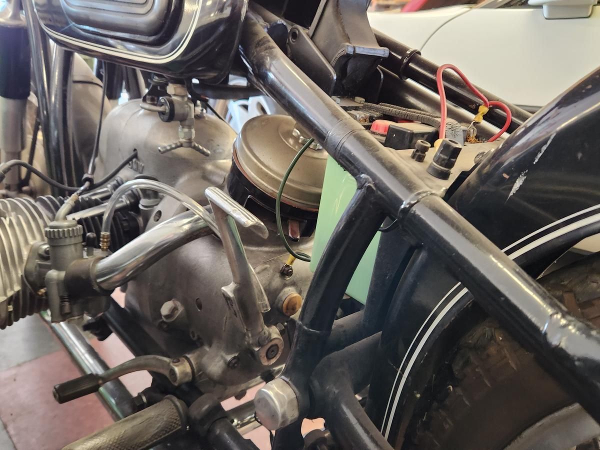 A close up of a motorcycle engine and rear wheel