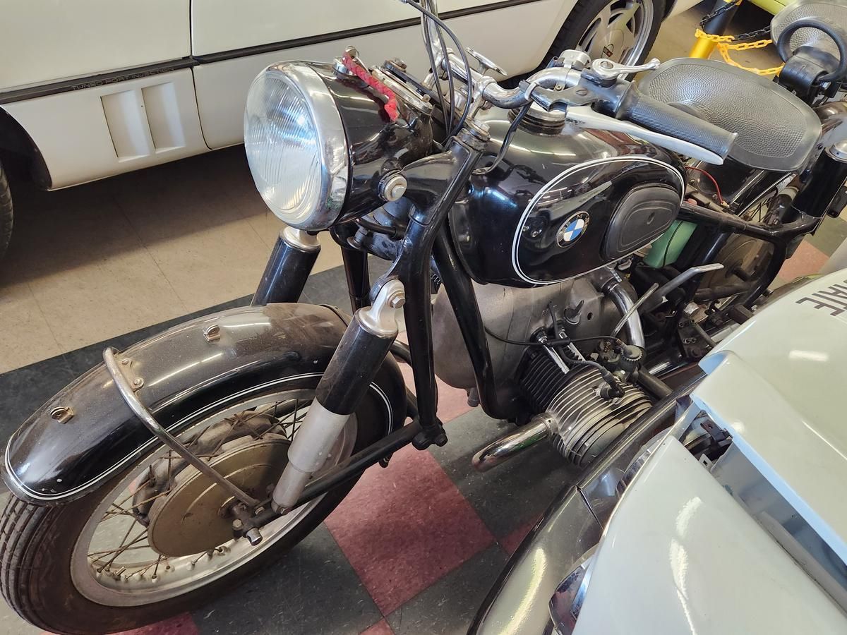A black motorcycle is parked next to a white car