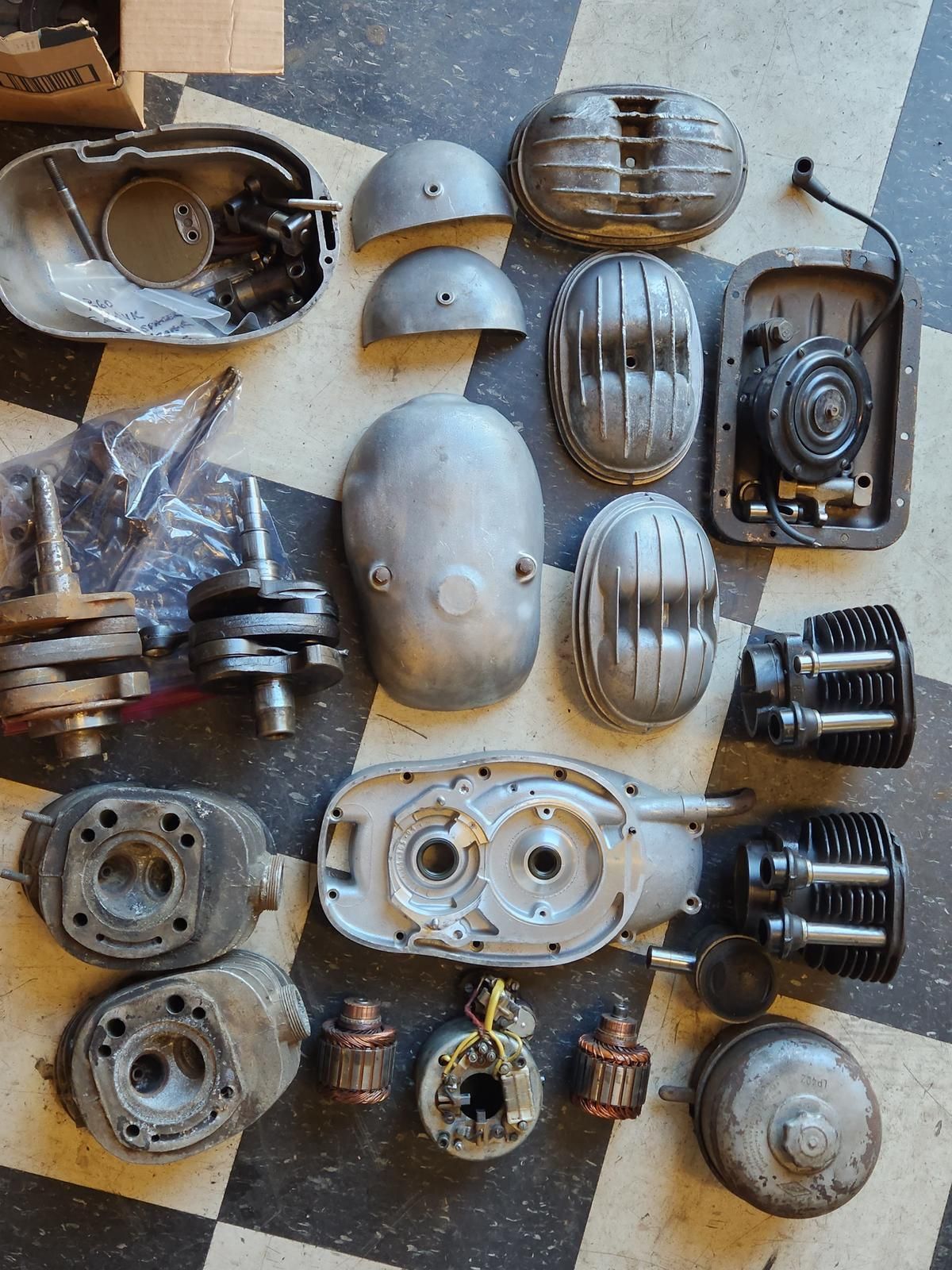 A bunch of motorcycle parts are sitting on a checkered floor.